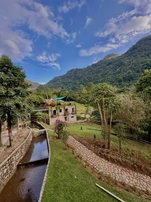 a house in a field next to a river at Hacienda La Amalia in Venecia