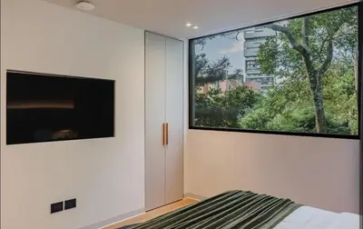 a bedroom with a bed and a large window at Lujoso apartamento en la zona más exclusiva de Medellín a 3 minutos de Provenza, muy amplio com jacuzzi in Medellín