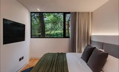 a bedroom with a bed and a large window at Lujoso apartamento en la zona más exclusiva de Medellín a 3 minutos de Provenza, muy amplio com jacuzzi in Medellín