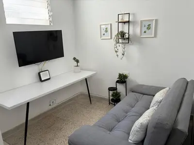 a living room with a couch and a table with a tv at El hospedaje de Ana in Medellín