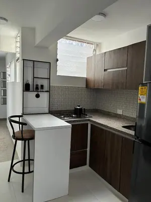 a kitchen with wooden cabinets and a white refrigerator at El hospedaje de Ana in Medellín
