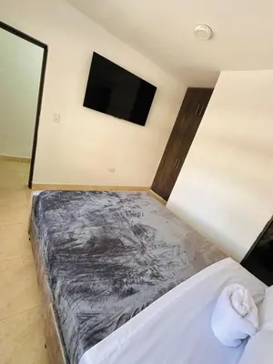 a bedroom with a bed and a flat screen tv at Studio apartment in Laureles, ideal central location in Medellín