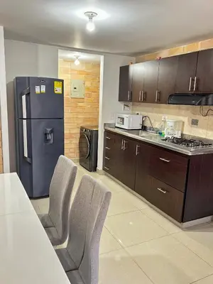 a kitchen with a refrigerator and a table and chairs at 2BR Apartment with Skyline View - El Tesoro, El Poblado in Medellín