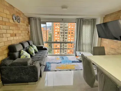 a living room with a couch and a large window at 2BR Apartment with Skyline View - El Tesoro, El Poblado in Medellín