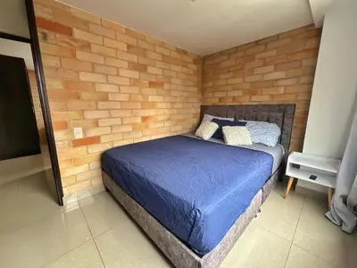 a bedroom with a blue bed in a brick wall at 2BR Apartment with Skyline View - El Tesoro, El Poblado in Medellín