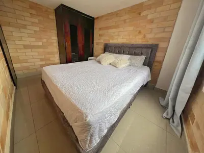 a bedroom with a bed with white sheets and pillows at 2BR Apartment with Skyline View - El Tesoro, El Poblado in Medellín