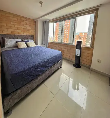 a bedroom with a bed with a blue comforter and two windows at 2BR Apartment with Skyline View - El Tesoro, El Poblado in Medellín