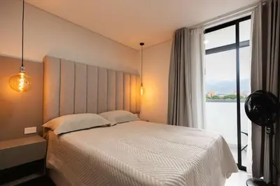 a bedroom with a bed and a large window at Exclusivo apartamento en laureles cerca al estadio in Medellín