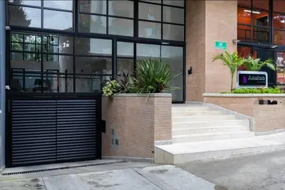 a building with a black garage door and some plants at Exclusivo apartamento en laureles cerca al estadio in Medellín