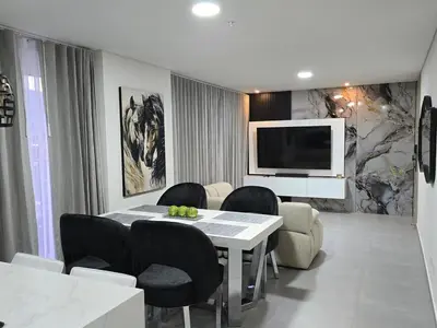 a dining room with a table and chairs and a television at Exclusivo apartamento en laureles cerca al estadio in Medellín