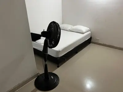 a black fan in a room with a bed at Hermoso apartamento con excelente ubicación in Medellín