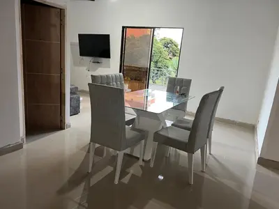 a dining room with a glass table and chairs at Hermoso apartamento con excelente ubicación in Medellín
