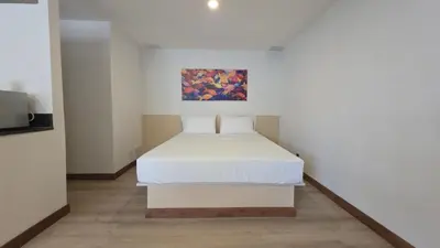 a bed in a white room with a painting on the wall at ABC-53 Housing in Medellín