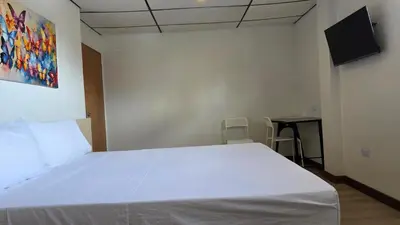 a bedroom with a white bed and a desk at ABC-53 Housing in Medellín