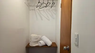 a bathroom with towels on a shelf next to a door at ABC-53 Housing in Medellín