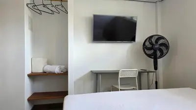 a bedroom with a tv and a desk with a fan at ABC-53 Housing in Medellín