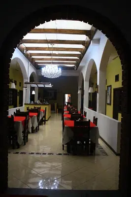 a dining room with tables and chairs and a chandelier at Hotel Colonial Manizales in Manizales