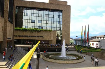 people walking around a fountain in front of a building at Hotel Colonial Manizales in Manizales