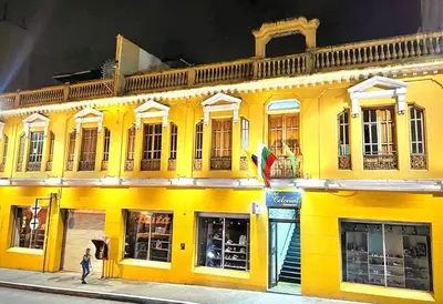 a yellow building with a person walking in front of it at Hotel Colonial Manizales in Manizales