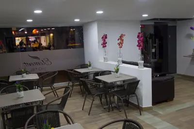 a restaurant with tables and chairs with flowers on the wall at Element Hotel in Medellín