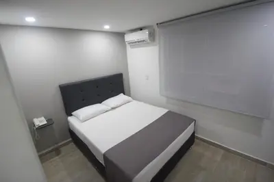 a small bedroom with a bed with a black headboard at Element Hotel in Medellín