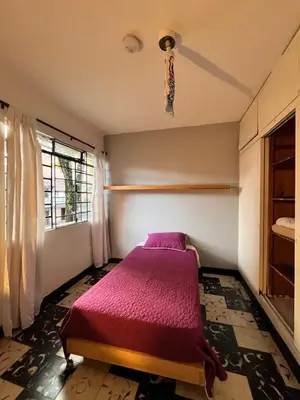 a bedroom with a purple bed in a room with a window at Selvática Alojamiento Eco in Medellín