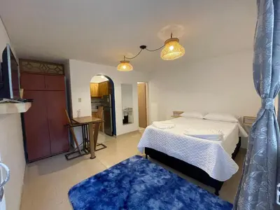 a bedroom with a bed and a blue rug at Selvática Alojamiento Eco in Medellín