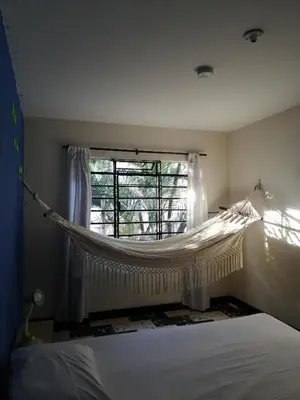 a bedroom with a hammock in front of a window at Selvática Alojamiento Eco in Medellín