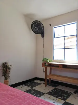 a bedroom with a piano and a window at Selvática Alojamiento Eco in Medellín
