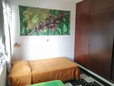 a bedroom with a bed and a painting on the wall at Selvática Alojamiento Eco in Medellín