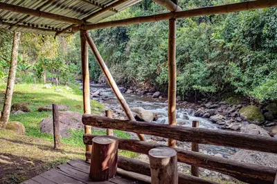 a wooden porch with a river in the background at Kantarrana Casa de Campo in Jardin
