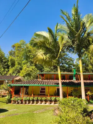 a house with two palm trees in front of it at Kantarrana Casa de Campo in Jardin
