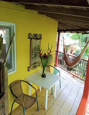 a table with a vase of flowers on a porch at Kantarrana Casa de Campo in Jardin
