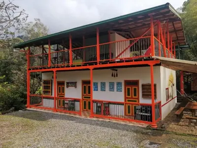 a house with orange trim and a balcony at Kantarrana Casa de Campo in Jardin