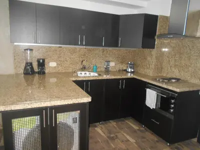 a kitchen with black cabinets and granite counter tops at Apartasuites AV in Medellín
