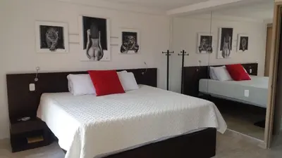 a bedroom with two beds with red and white pillows at Apartasuites AV in Medellín