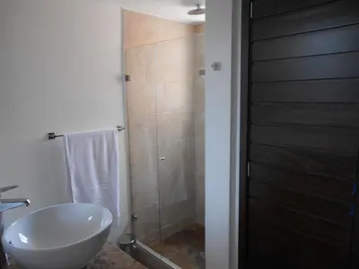 a bathroom with a white sink and a shower at Apartasuites AV in Medellín