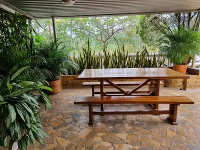 a picnic table and benches on a patio with plants at San Jeronimo Cabaña in San Jerónimo