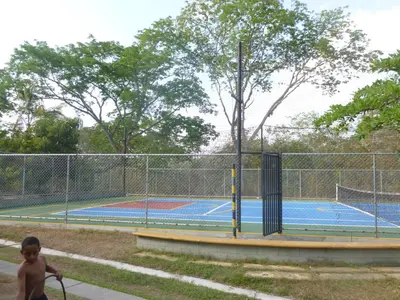 a young boy walking past a tennis court at San Jeronimo Cabaña in San Jerónimo