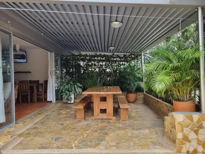 a patio with a wooden picnic table and plants at San Jeronimo Cabaña in San Jerónimo