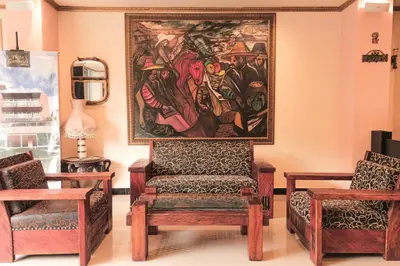a painting hanging on the wall in a room with two chairs at Hotel Plaza Garibaldi in Caldas