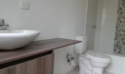 a white bathroom with a sink and a toilet at Cabaña Familiar La Aldea Doradal in Gesen