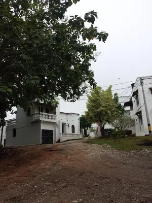 a white building with a porch and a tree at Cabaña Familiar La Aldea Doradal in Gesen