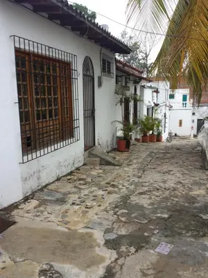 an alley in front of a white house with a gate at Cabaña Familiar La Aldea Doradal in Gesen