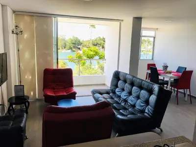 a living room with a couch and chairs and a table at Aptos vista al Embalse, frente al lago, Restaurantes, Bares in Guatapé