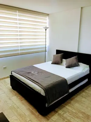 a large bed in a room with a window at Aptos vista al Embalse, frente al lago, Restaurantes, Bares in Guatapé