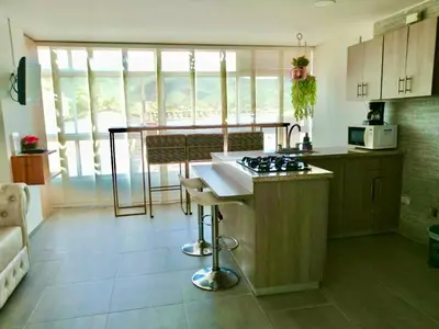 a kitchen with a stove and a counter top at Aptos vista al Embalse, frente al lago, Restaurantes, Bares in Guatapé