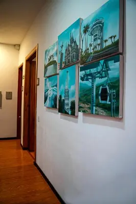a wall with five paintings on it with a hallway at Casabella Hotel in Manizales