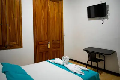 a bedroom with a bed with a desk and a television at Casabella Hotel in Manizales