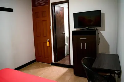 a room with a door and a television and a table at Casabella Hotel in Manizales